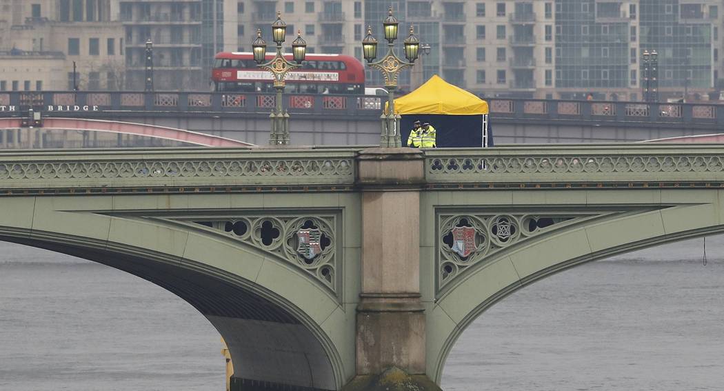 Police officers and forensics investigators and police officers work on Westminster Bridge on Wednesday morning after an attack by a man driving a car in London, Britain, March 23, 2017. (Darren S ...