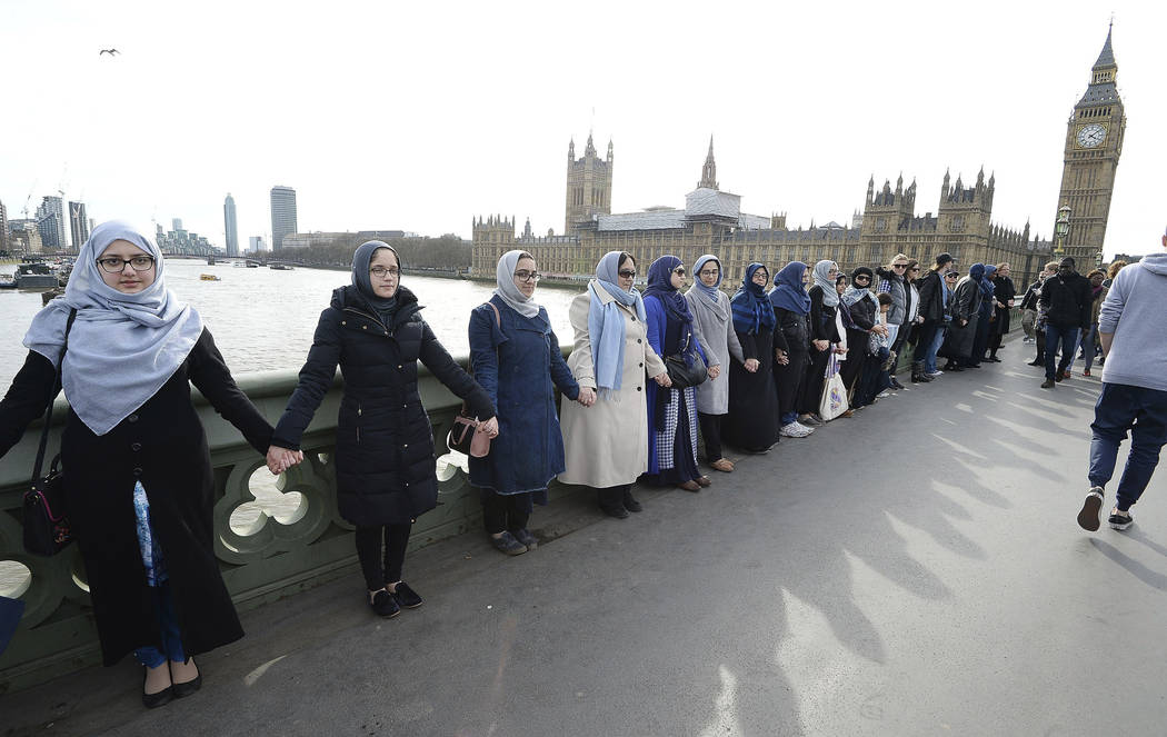 A group of women, some with their daughters, link hands on Westminster bridge in central London in an act of solidarity organized by Women's March London to pay tribute to the victims of the Westm ...
