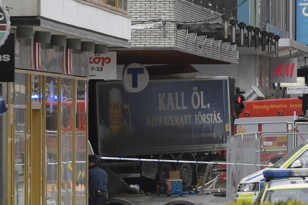 The rear of a truck, left, protrudes after it crashed into a department store injuring several people in central Stockholm, Sweden, Friday April 7, 2017. (Anders Wiklund, TT News Agency via AP)