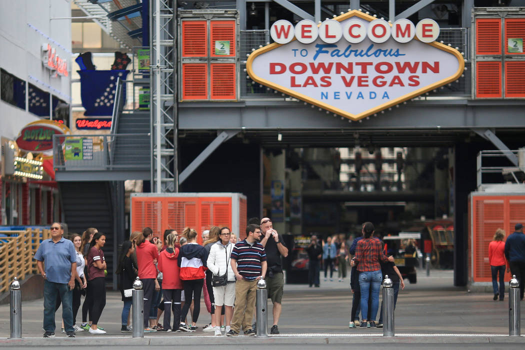 Pedestrians wait to cross the street at the intersection of Las Vegas Boulevard and Fremont Street on Friday, April 7, 2017. (Brett Le Blanc/Las Vegas Review-Journal) @bleblancphoto