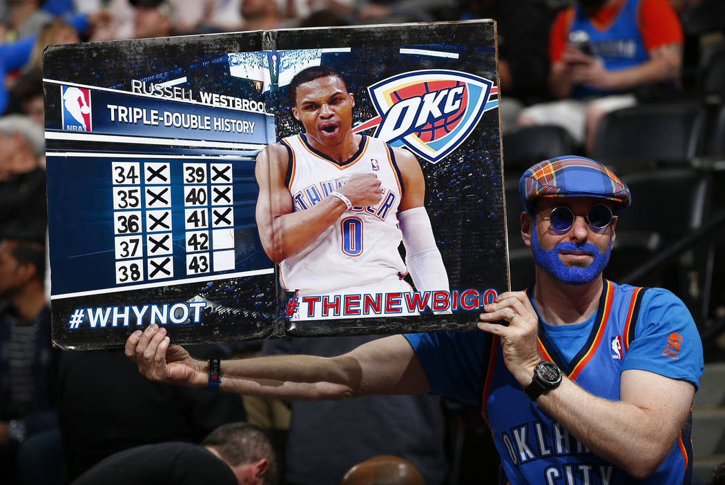 An Oklahoma City Thunder fan shows the Russell Westbrook triple double history board during the first half of a basketball game against the Denver Nuggets Sunday, April 9, 2017, in Denver. (Jack D ...