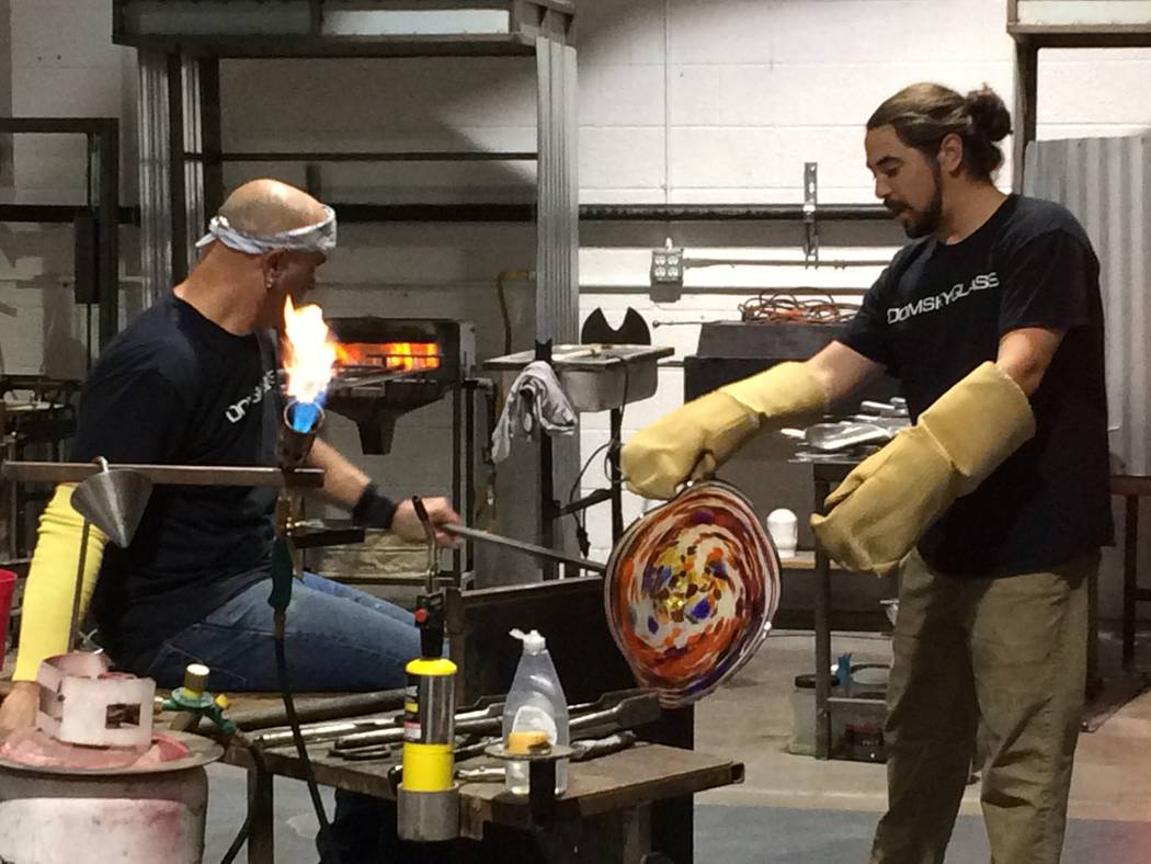 Larry Domsky, left, works the hot glass as assistant Matt Humphrey helps April 7, 2017, during an exhibition at Domsky Glass, 2758 S. Highland Drive. Owned by Larry and his wife, Barbara, the stud ...