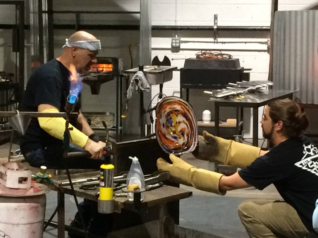 Larry Domsky, left, works the hot glass as assistant Matt Humphrey helps April 7, 2017, during an exhibition at Domsky Glass, 2758 S. Highland Drive. Owned by Larry and his wife, Barbara, the stud ...