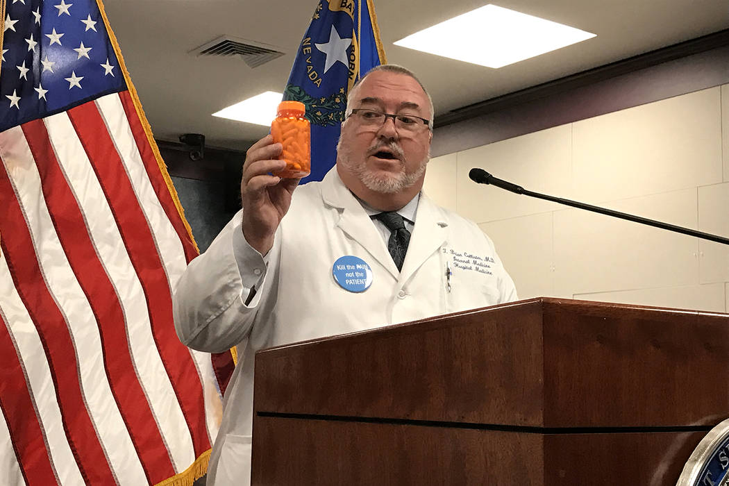 Dr. Brian Callister shows the quantity of pills he said a doctor would have to prescribe for a terminally-ill patient to commit suicide. Callister and others spoke at a press conference on Wednesd ...