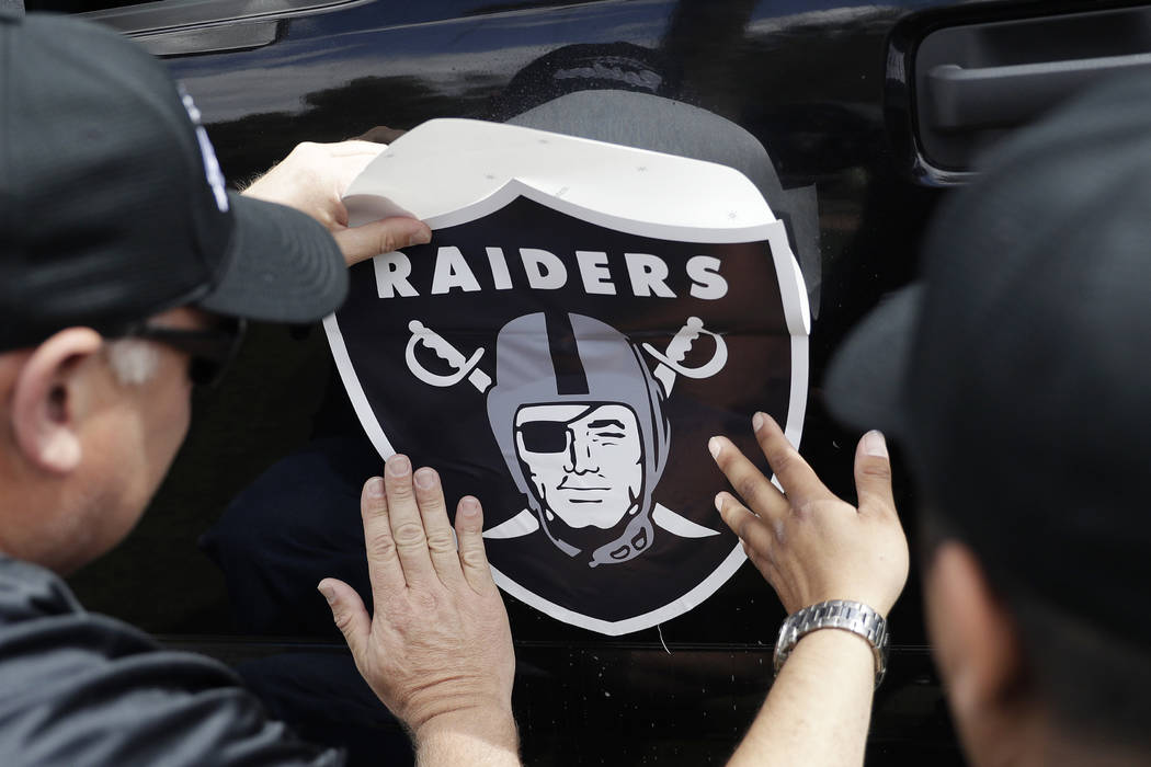 Members of a laborers union affix a Raiders logo to a truck, Monday, March 27, 2017, in Las Vegas. (John Locher/AP)