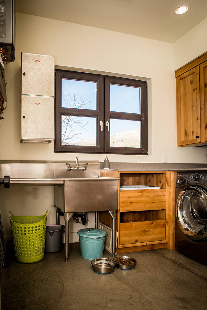 The laundry room is lined with knotty pine Alderwood cabinets, and a couple of insulated room service delivery bins obtained from the Debbie Reynolds Hotel serve as storage. (Tonya Harvey)
