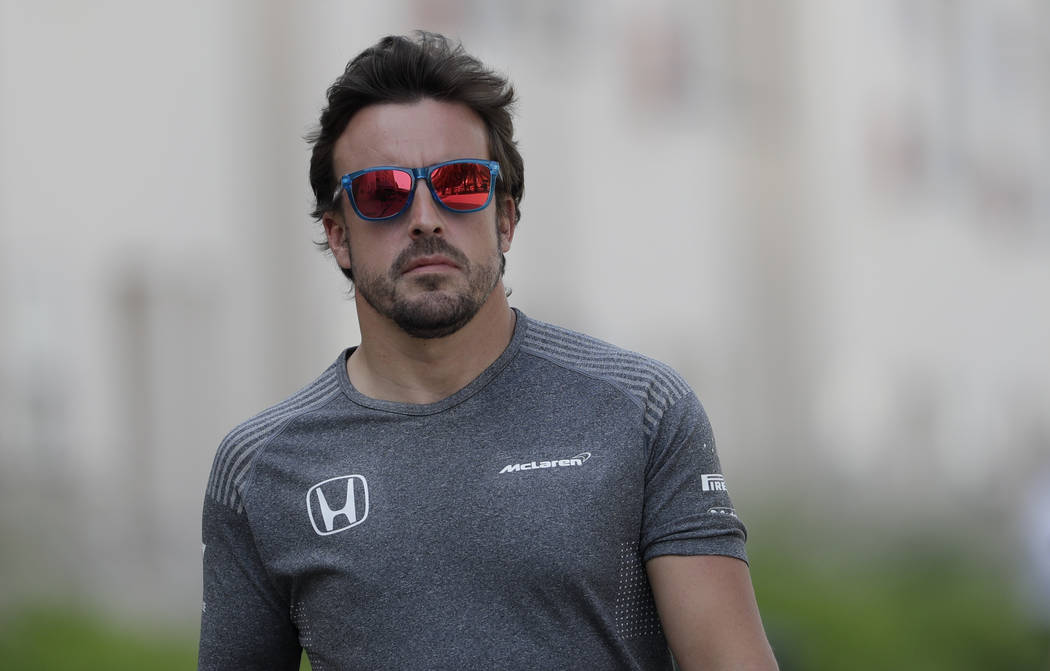 McLaren driver Fernando Alonso of Spain, walks in the paddock prior to a news conference, ahead the Bahrain Formula One Grand Prix at the Formula One Bahrain International Circuit in Sakhir, Bahra ...