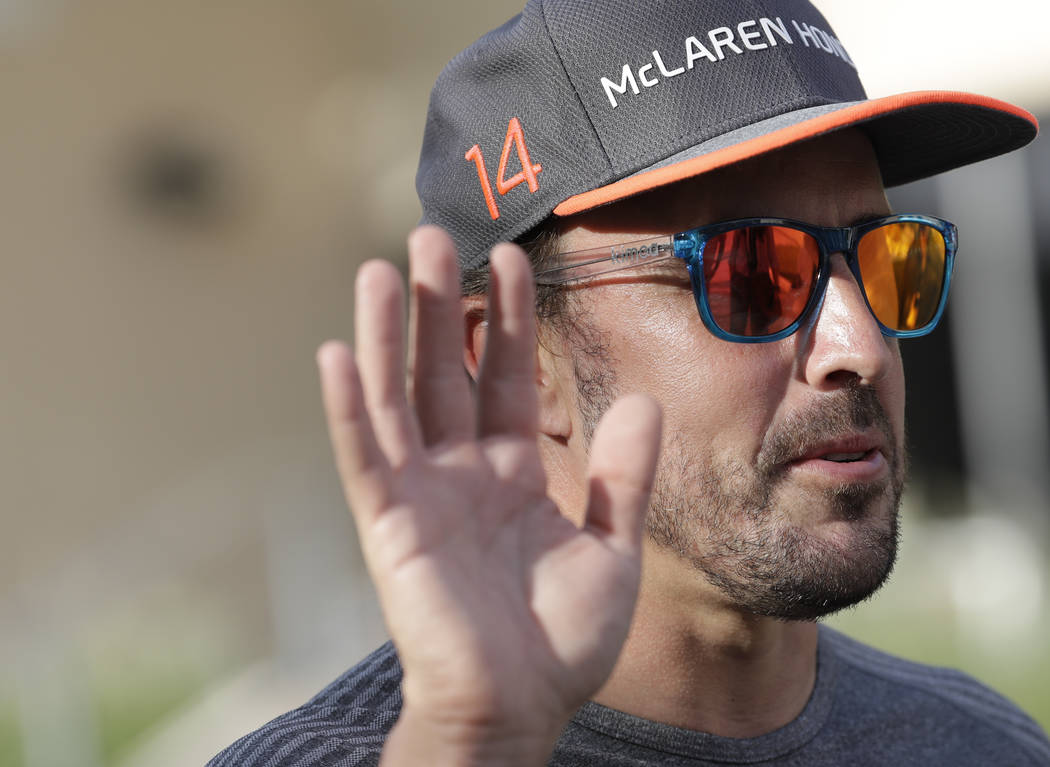 McLaren driver Fernando Alonso of Spain, gives an interview to a reporter in the paddock, ahead of the Bahrain Formula One Grand Prix at the Formula One Bahrain International Circuit in Sakhir, Ba ...