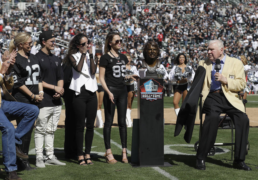 Former Oakland Raiders head coach John Madden, right, unveils a Pro Football Hall of Fame bust for former quarterback Ken Stabler next to Stabler's family at a ceremony during halftime of an NFL f ...