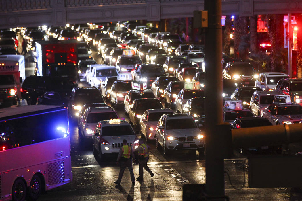 Las Vegas police direct traffic as firefighters and other emergency personnel respond to the scene after part of the roof of the Bellagio hotel-casino caught fire in Las Vegas on Thursday, April 1 ...