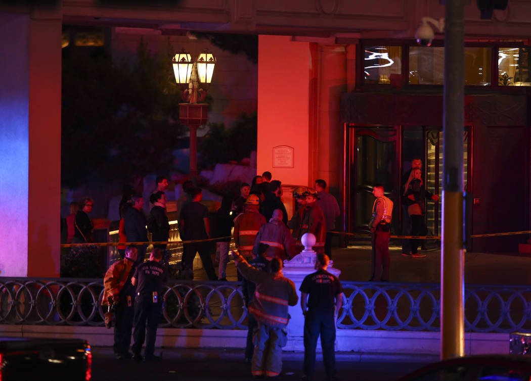 Pedestrians outside of the Bellagio hotel-casino as Clark County Fire Department and other emergency personnel respond after part of the roof of the hotel-casino caught fire in Las Vegas on Friday ...