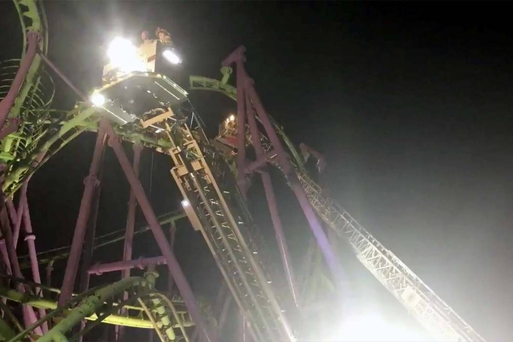 In this image made from a video provided by the Prince George’s County Fire Department, firefighters respond to the scene after over a dozen people became stuck when a roller coaster stalle ...