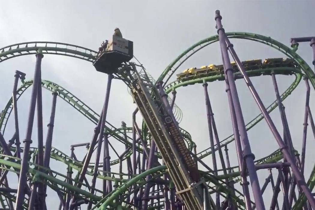 In this image made from a video provided by the Prince George’s County Fire Department, firefighters respond to the scene after over a dozen people became stuck when a roller coaster stalle ...