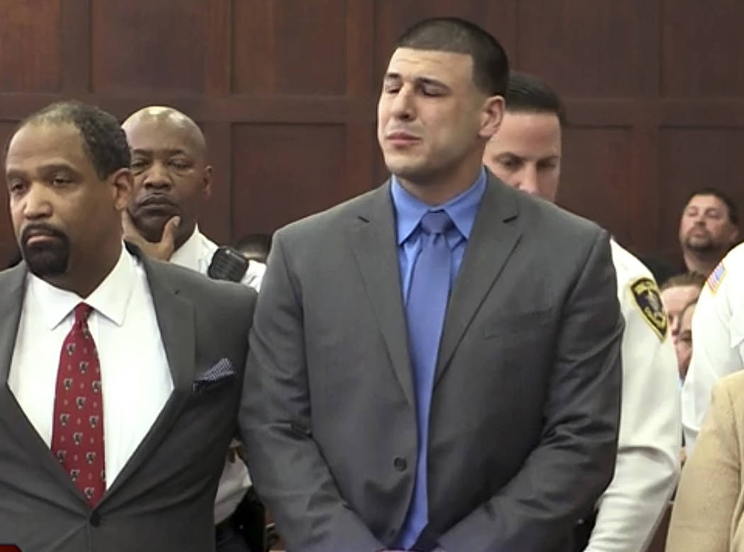 In this still image from video, Aaron Hernandez, right, listens beside defense attorney Ronald Sullivan, Friday, April 14, 2017, in court in Boston, as he is pronounced not guilty of murder in the ...