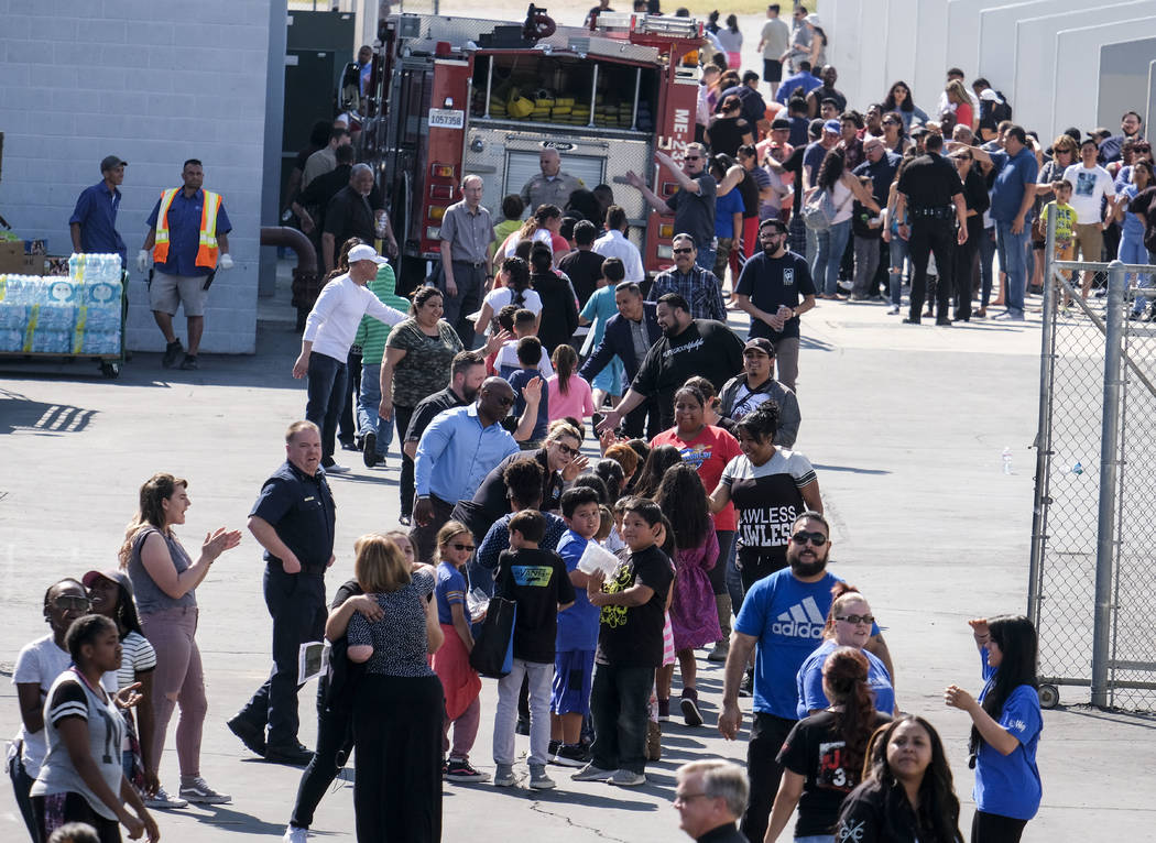 School staff greet students at North Park Elementary School, in relief at Cajon High School, Monday, April 10, 2017, in San Bernardino, Calif., after a deadly shooting occurred at the elementary s ...
