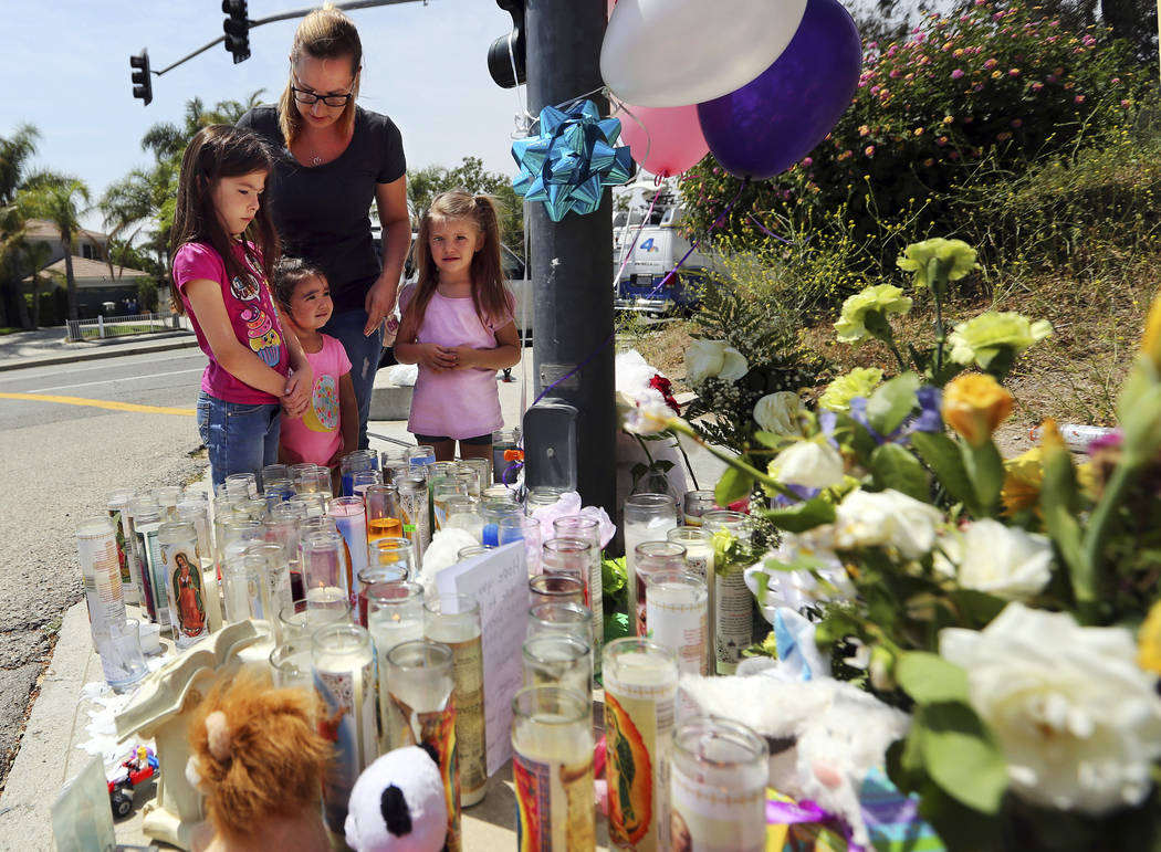 Lena Hammerling and her daughters Melissa, left, and Maci, right, and an unidentified child look at a sidewalk memorial dedicated to the teacher and student who were shot to death Monday at North  ...