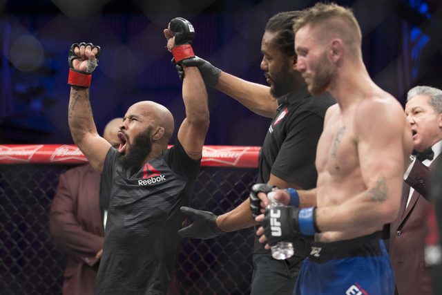 Demetrious Johnson, left, raises his arm in victory against Timothy Elliot in the The Ultimate Fighter 24 Finale flyweight title bout at the Palms hotel-casino Pearl Theater on Saturday, Dec. 3, 2 ...