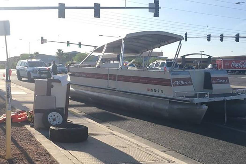 A pontoon boat sits in an eastbound lane of American Pacific Drive after falling off a trailer Friday evening. (Max Michor/Las Vegas Review-Journal)