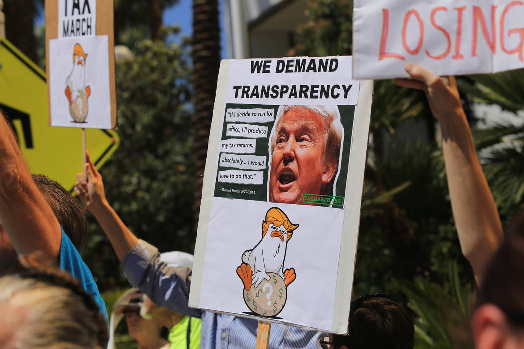 Demonstrators hold signs in an effort to get President Donald Trump to release his tax returns during a tax day protest at Trump International Hotel on Saturday, April 15, 2017. Brett Le Blanc Las ...