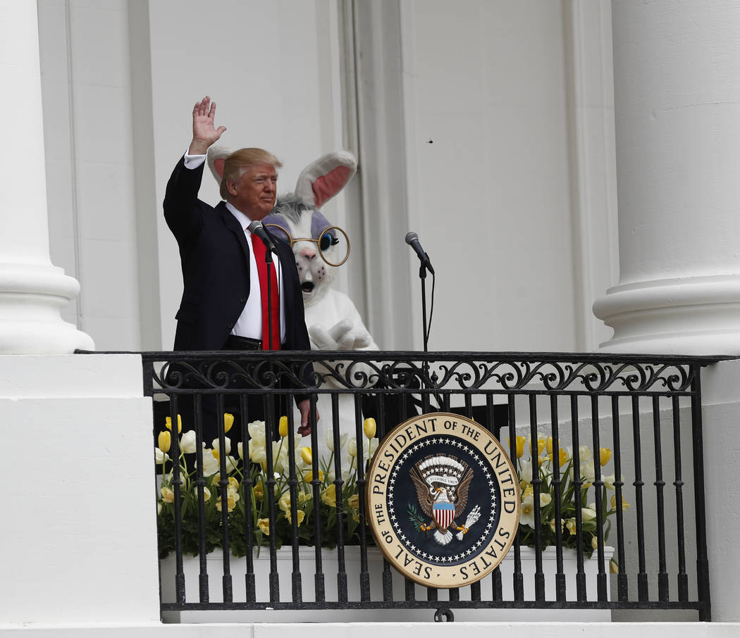 President Donald Trump, accompanied by the Eastern bunny, waves from the Truman Balcony of the White House in Washington, Monday, April, 17, 2017, during the annual White House Easter Egg Roll. (C ...