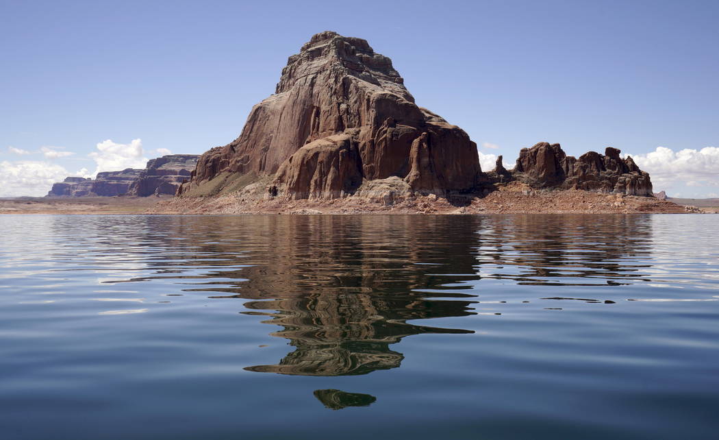Gregory Butte is reflected in Lake Powell near Page, Ariz., May 25, 2015. Lake Powell on the Colorado River provides water for Nevada, Arizona and California. A severe drought in recent years, com ...
