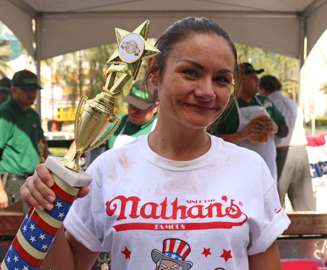 Michelle Lesco stands with her trophy after Nathan's Famous hosted the Nevada qualifier for the Fourth of July International Hot Dog-Eating Contest at New York New York hotel-casino, Saturday, Apr ...