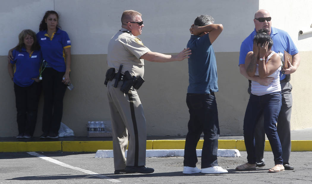 People react after arriving to a crime scene where a stabbing occurred at the Arco gas station located on Bonanza Rd. and N Lamb Blvd. on Wednesday, April 19, 2017, in Henderson. One person has di ...