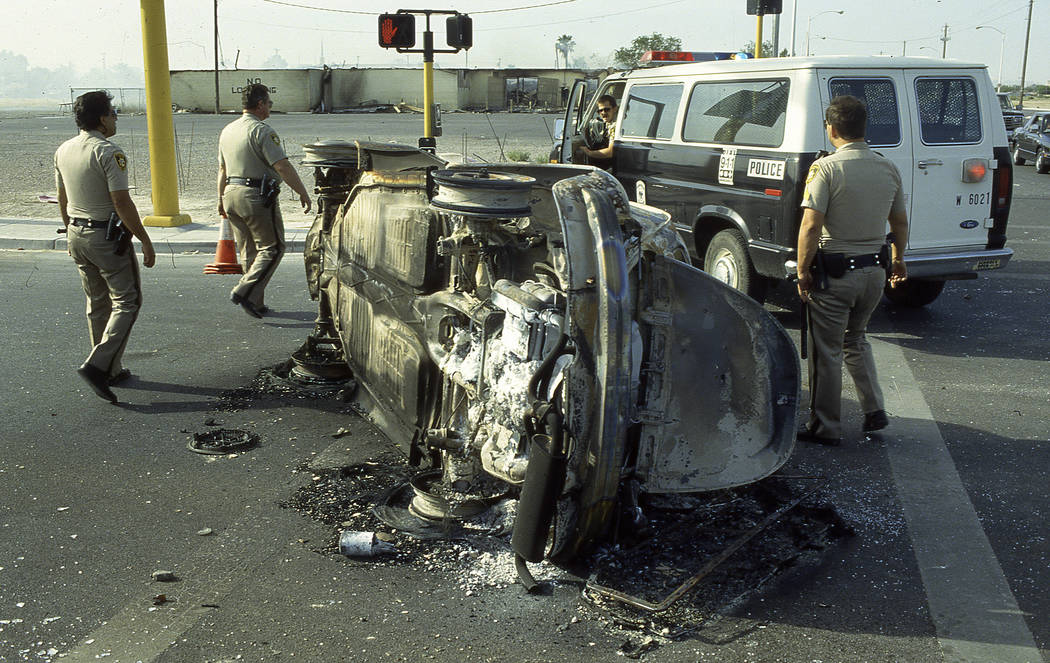 Las Vegas police examine the remains of a torched car on May 1, 1992.  At least 90 fires were set the night prior, 40 were buildings the rest involved cars and trash cans. Las Vegas Review-Journal ...