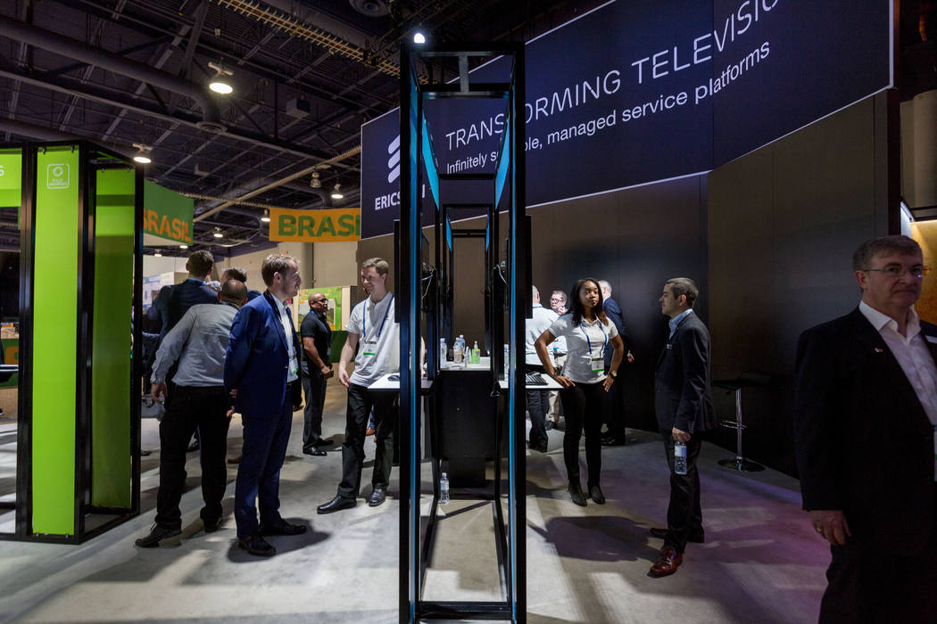 Ericsson employees speak with participants about their innovative software in the world of television during the National Association of Broadcasters exposition, the NAB Show, at the Las Vegas Con ...