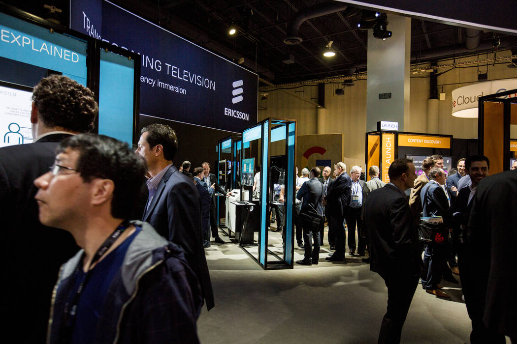 Ericsson employees speak with participants about their innovative software in the world of television during the National Association of Broadcasters exposition, the NAB Show, at the Las Vegas Con ...