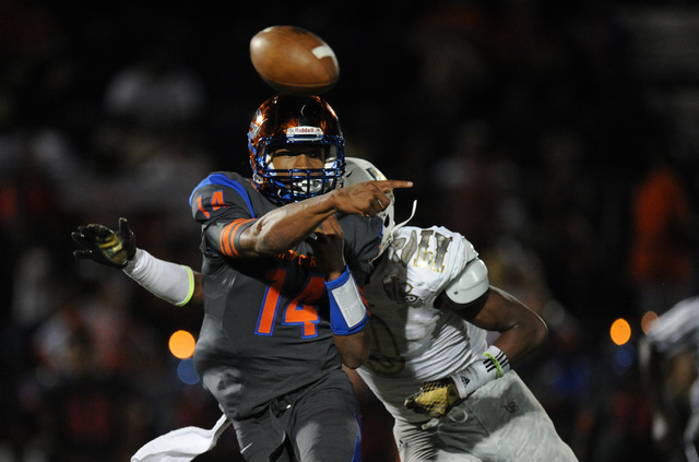 Bishop Gorman quarterback Dorian Thompson-Robinson (14) passes the ball while on being chase ...