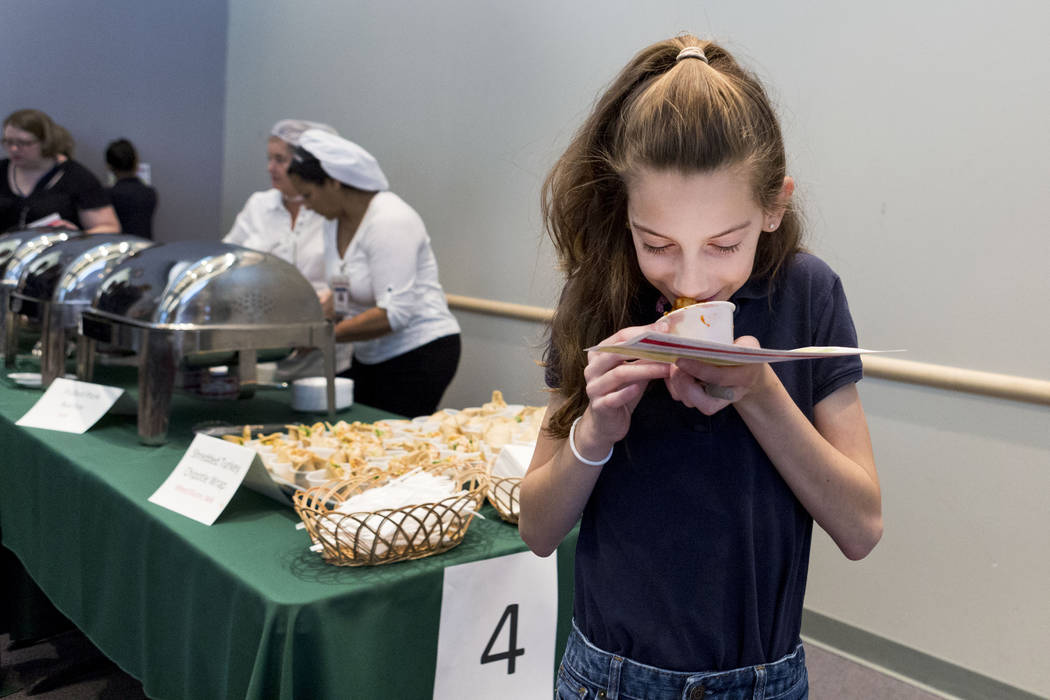 Ralph Cadwallader Middle School student Morgan Renfro, 11, takes a bite of a sample during Clark County School District sampling of their 2017-2018 cafeteria lunch menu to different schools in CC ...