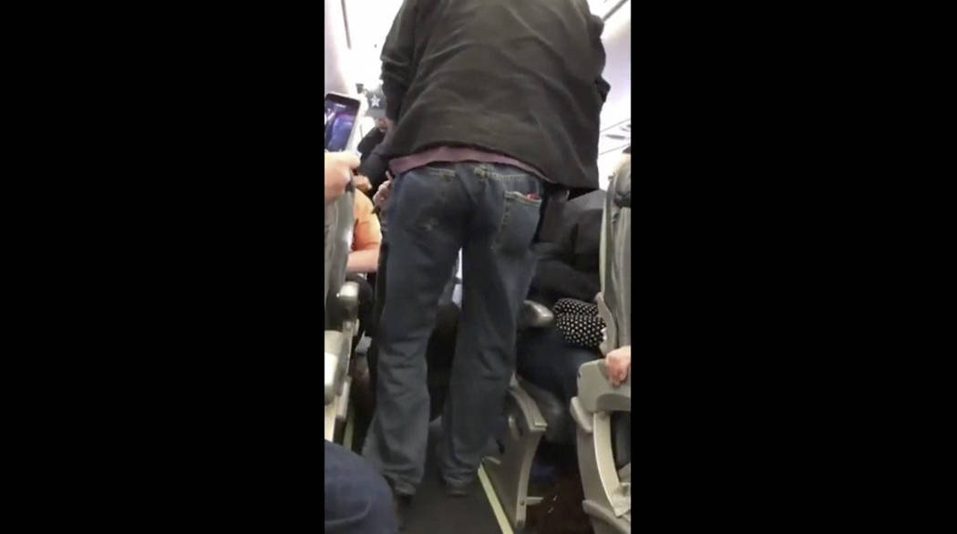 In an image made from a video, a passenger is removed from a United Airlines flight in Chicago, April 9, 2017. Video of police officers dragging the passenger from an overbooked United Airlines fl ...