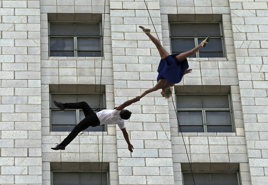 Dancers from Bandaloop aerial dance troupe perform to a medley of songs from the movie "La La Land" off the side of Los Angeles City Hall, during "La La Land Day" festivities Tuesday, April 25, 20 ...