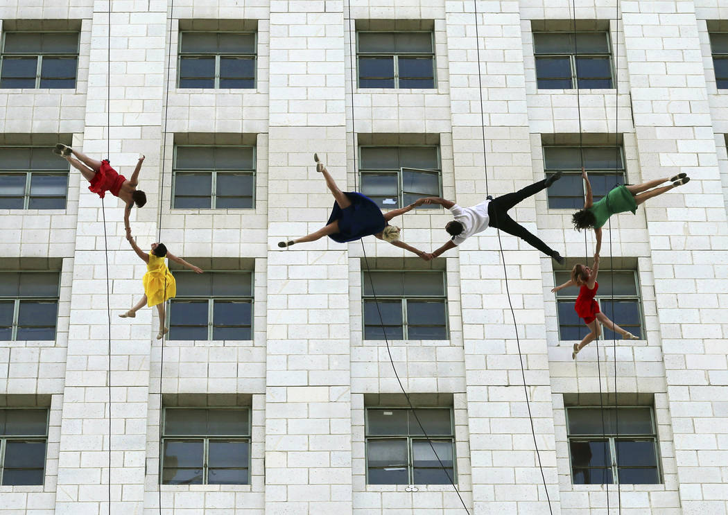 Dancers from Bandaloop aerial dance troupe perform to a medley of songs and dances from the movie "La La Land" off the side of Los Angeles City Hall, during "La La Land Day" festivities Tuesday, A ...