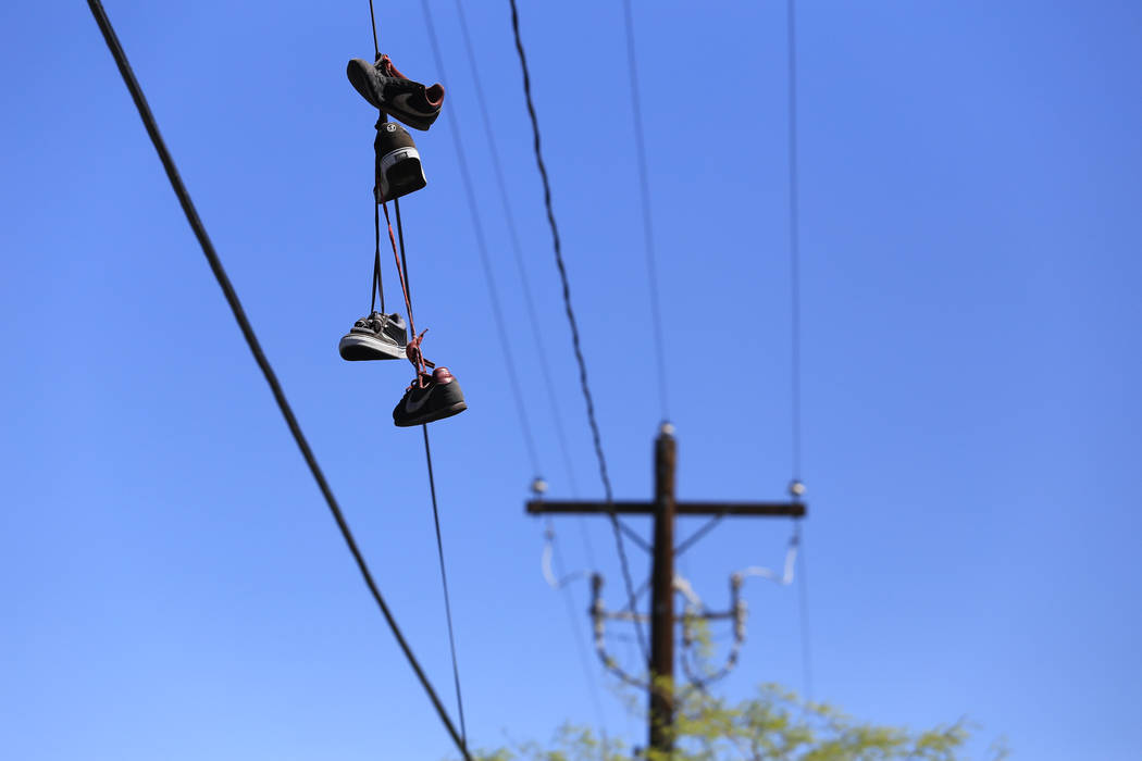 Shoes hang from a power line on Main Street at Foremaster Lane in Las Vegas, on Friday, April 28, 2017, in front of land that the city of Las Vegas wants to turn into a campus that will bring home ...