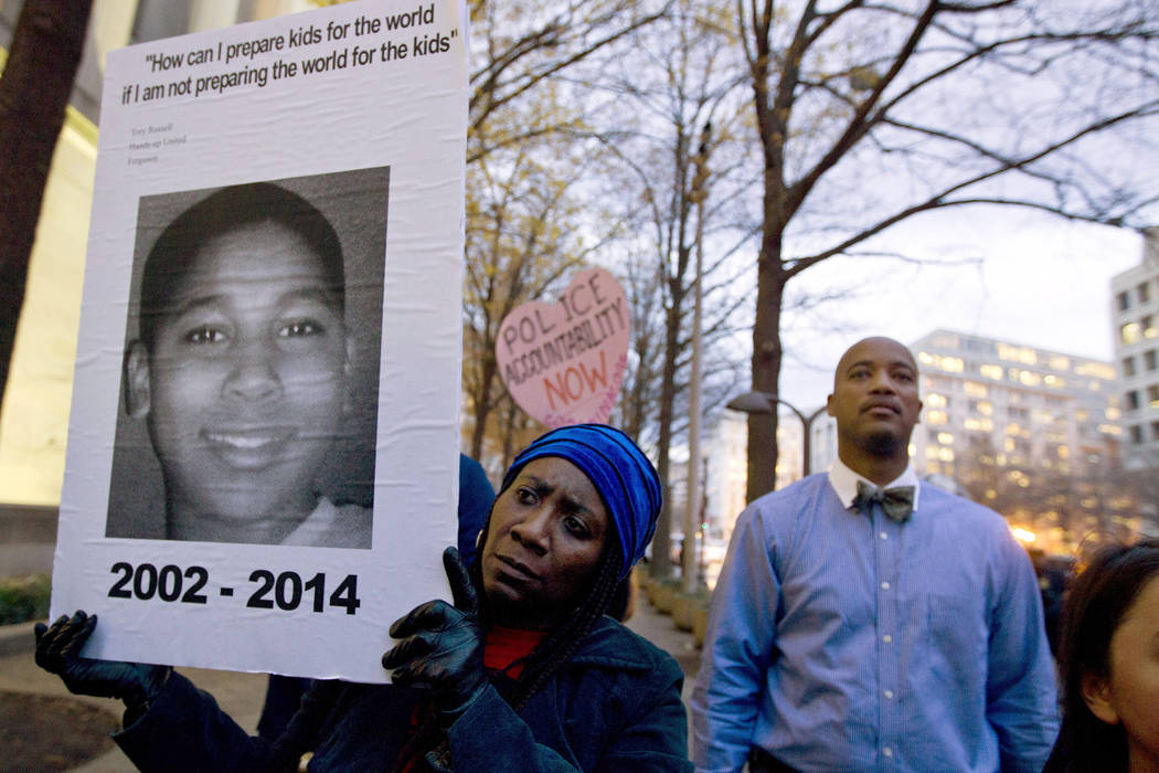 Tomiko Shine holds up a picture of Tamir Rice during a protest Monday, Dec. 1, 2014, in Washington, D.C. (Jose Luis Magana/File, AP)
