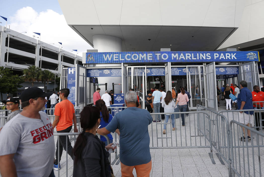 Fans enter Marlins Park stadium before the start of a baseball game between the Miami Marlins and the Atlanta Braves, Tuesday, April 11, 2017, in Miami. (AP Photo/Wilfredo Lee)