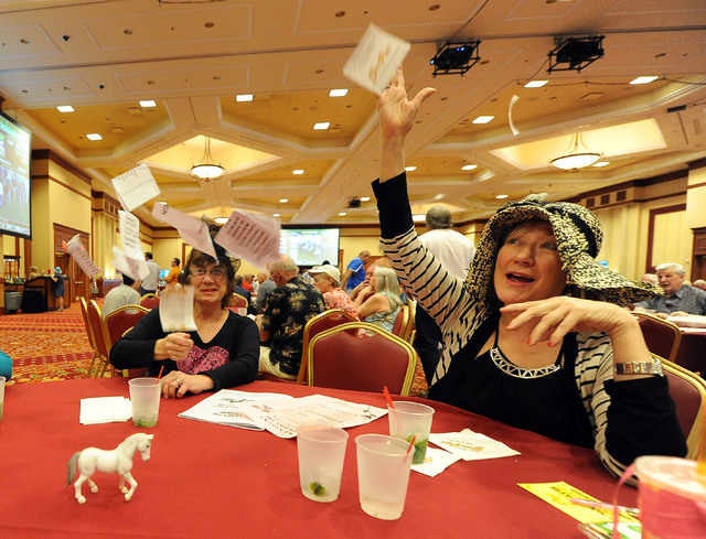 Marge Raglo, left, and Teresa VanAcker, both members of the Desert Newcomers Club, throw their non-winning tickets up in the air in disgust during a viewing party for the Kentucky Derby horse race ...
