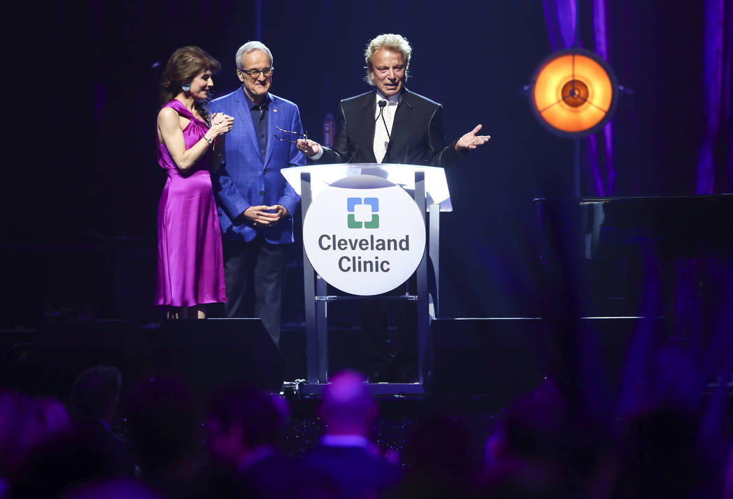 Inaugural Caregiver Award recipient Siegfried Fischbacher, right, receives a standing ovation as he takes the stage alongside Larry and Camille Ruvo during Keep Memory Alive's 21st annual Power of ...
