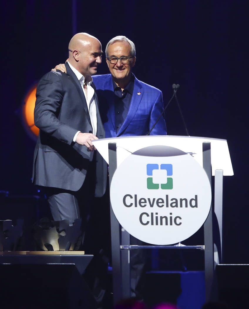 Larry Ruvo, co-founder and chairman of Keep Memory Alive, right, welcomes tennis great and Las Vegas resident Andre Agassi to the stage during Keep Memory Alive's 21st annual Power of Love gala, r ...