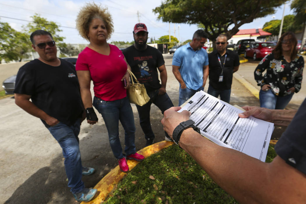 Miami-Dade Police Detective Daniel Garcia, far right, holds a briefing before conducting an operation to remove squatters from a house in Miami on Tuesday, April 18, 2017. Looking on, from left, a ...