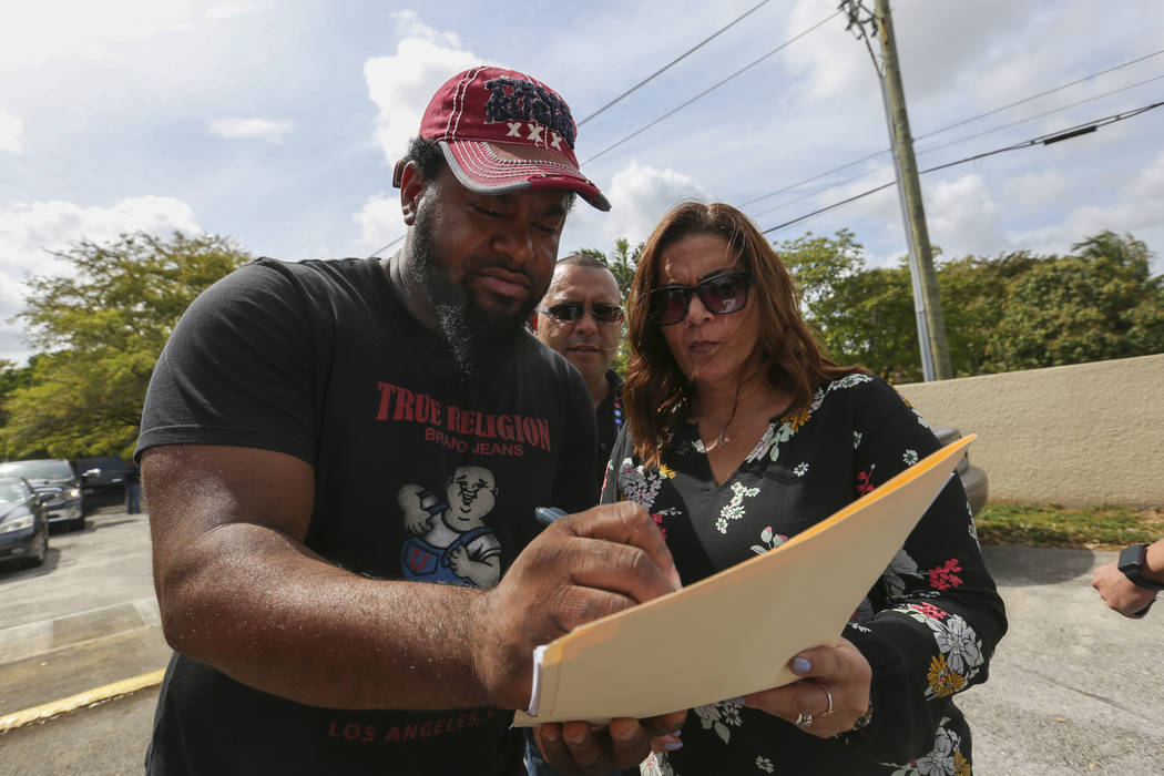 A homeowner who reported having squatters in his Miami property draws a map of his house for Miami-Dade Police Detective Ivette Perez, before she and other officers conduct an operation to remove  ...