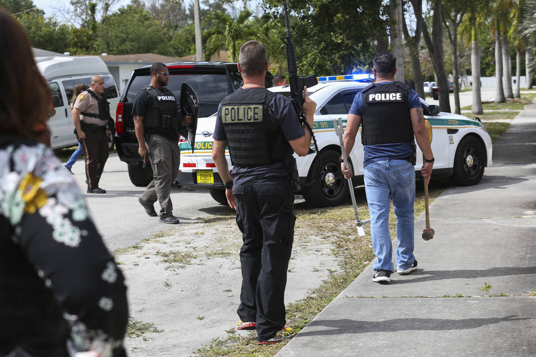Miami-Dade police officers conduct an operation to remove squatters from a house in Miami on Tuesday, April 18, 2017. Matias J. Ocner