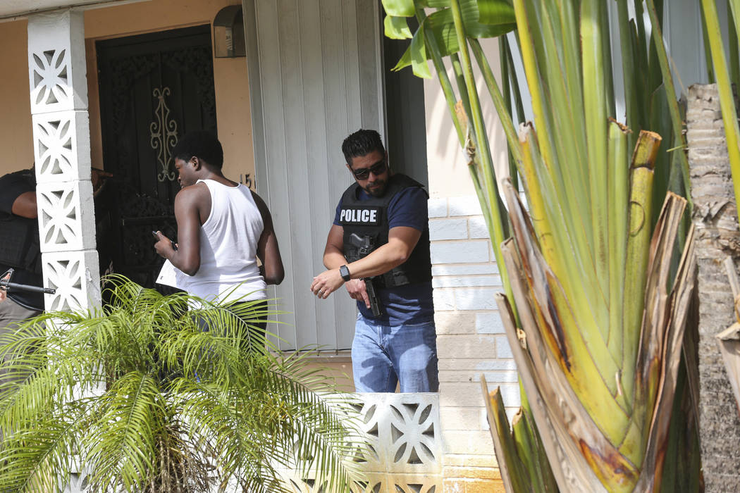 Miami-Dade Police Detective Roody Gaston, left, and Sgt. Carlos Luffi remove a suspected squatter from a house in Miami on Tuesday, April 18, 2017. Matias J. Ocner