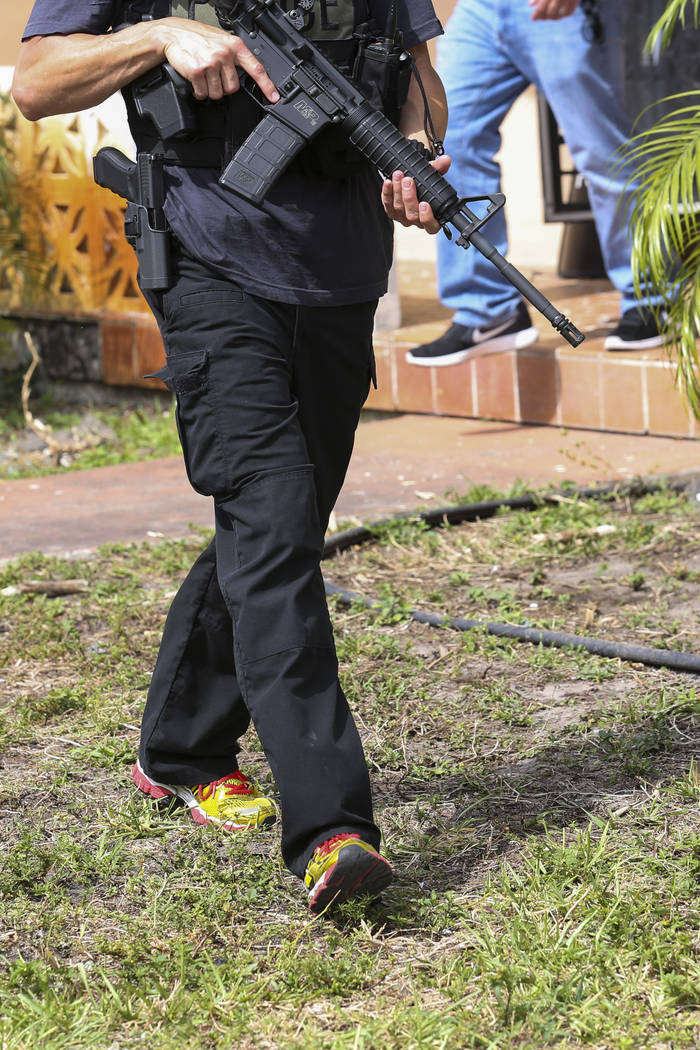Miami-Dade Police Detective Daniel Garcia conducts an operation to remove squatters from a house in Miami on Tuesday, April 18, 2017. Matias J. Ocner
