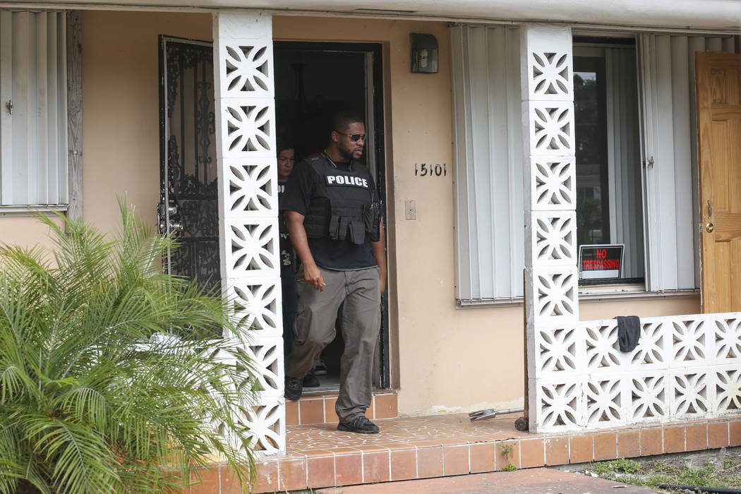 Miami-Dade Police detectives Roody Gaston, right, and Ivette Perez conduct an operation to remove squatters from a house in Miami on Tuesday, April 18, 2017. Matias J. Ocner