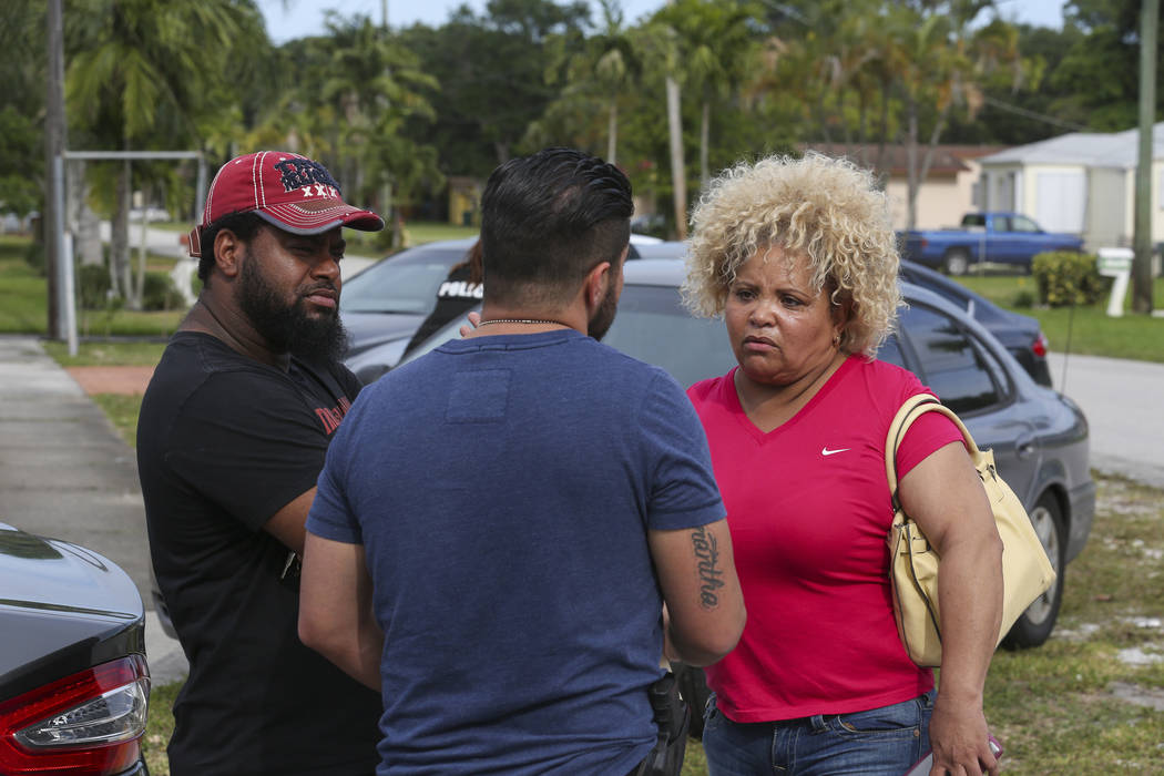 Miami Dade Police Sgt. Carlos Luffi, center, tells Valentina De Leon, right, and her husband that police cannot remove suspected squatters from their house in Miami on Tuesday, April 18, 2017. Mat ...