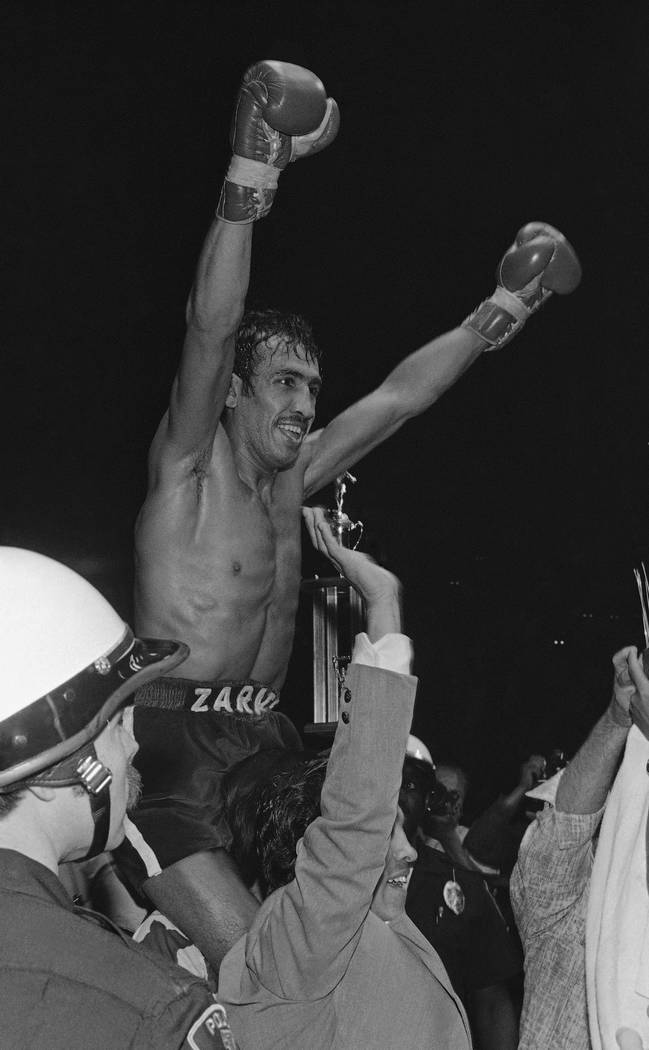 Bantamweight champion (WBC) Carlos Zarate raises arms in victory aftor knocking out the WBA champ, Alfonso Zamora, in the fourth round of a 10 round bout Saturday, April 23, 1977 in Los Angeles. I ...