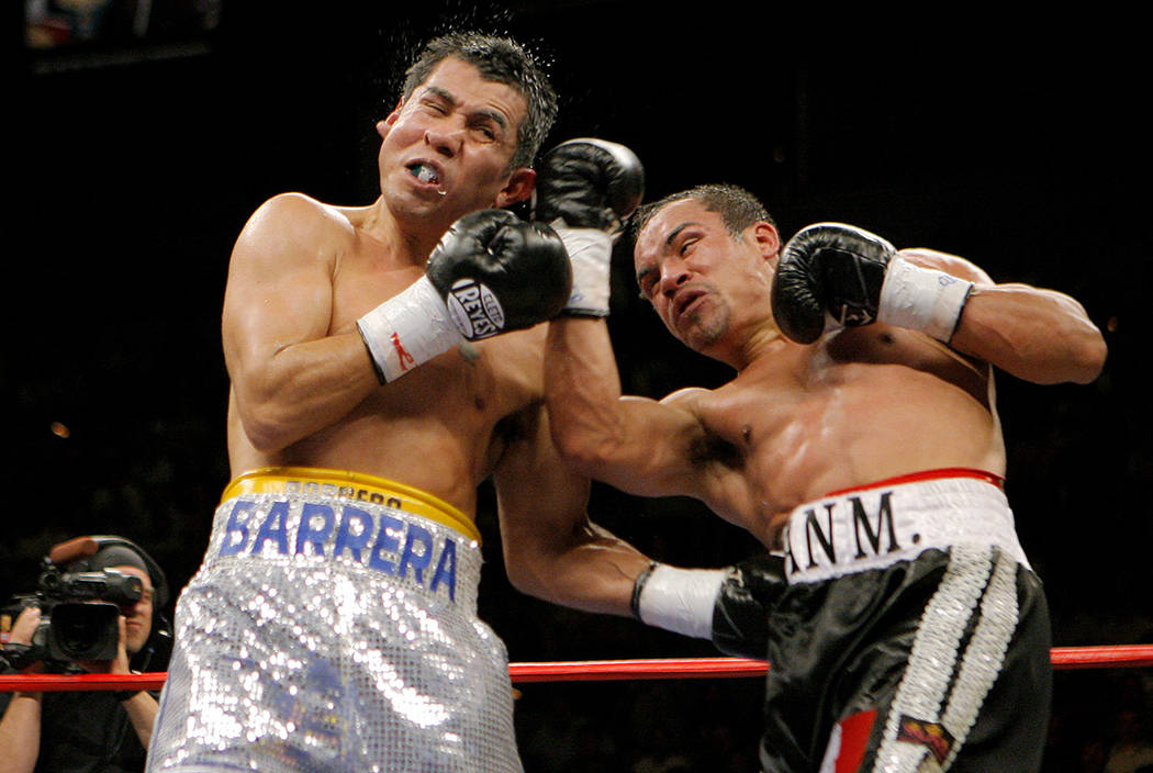 Marco Antonio Barrera, left, of Mexico, takes a punch from Juan Manuel Marquez, also of Mexico, in the sixth round of a WBC super featherweight championship boxing match on Saturday, March 17, 200 ...